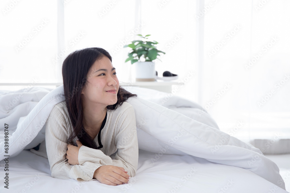 Beautiful portrait young asian woman smile lying on bed in bedroom at home, teenager girl relax and cozy after awake, domestic life, lifestyles and comfortable concept. Beautiful portrait young asian woman smile lying on bed in bedroom at home, teenager girl relax and cozy after awake, domestic life, lifestyles and comfortable concept.