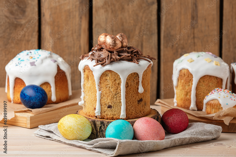 Delicious Easter cake with icing, chocolate nest and painted eggs on wooden table. Side view. Delicious Easter cake with icing, chocolate nest and painted eggs on wooden table. Side view.