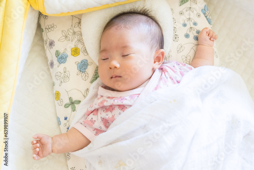 ベビーベッドで寝ている日本人の赤ちゃん
