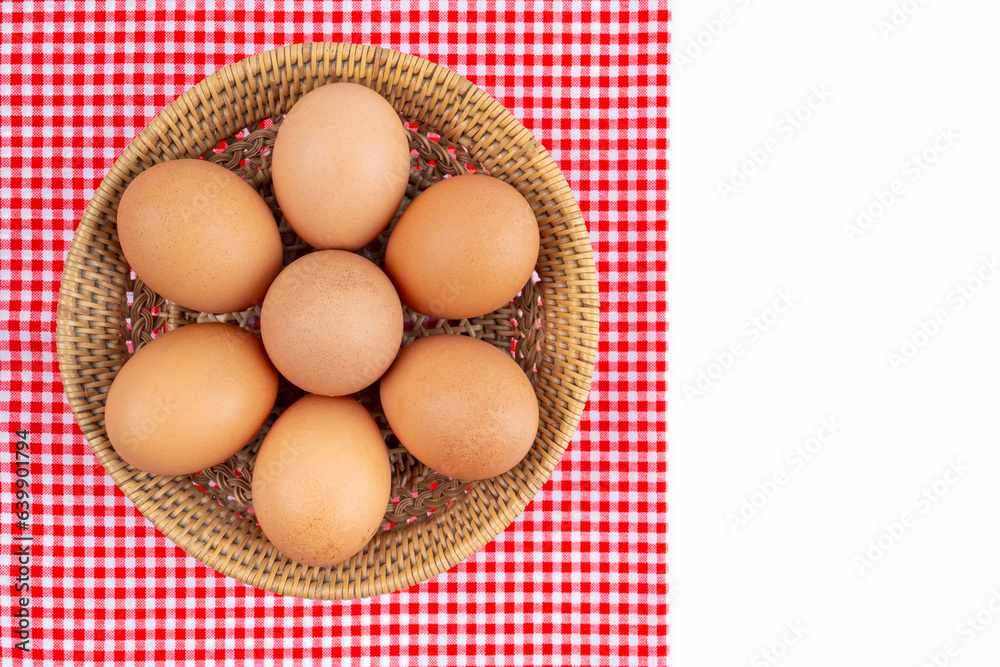 The Fresh farm eggs in wooden weave basket with red tablecloth isolated on white background, and copy space for your text. The Fresh farm eggs in wooden weave basket with red tablecloth isolated on white background, and copy space for your text.