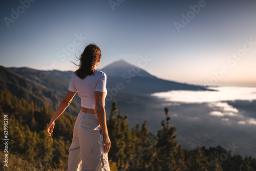 Girl standing on a rock above the clouds in front of volcano Teide, Tenerife photo