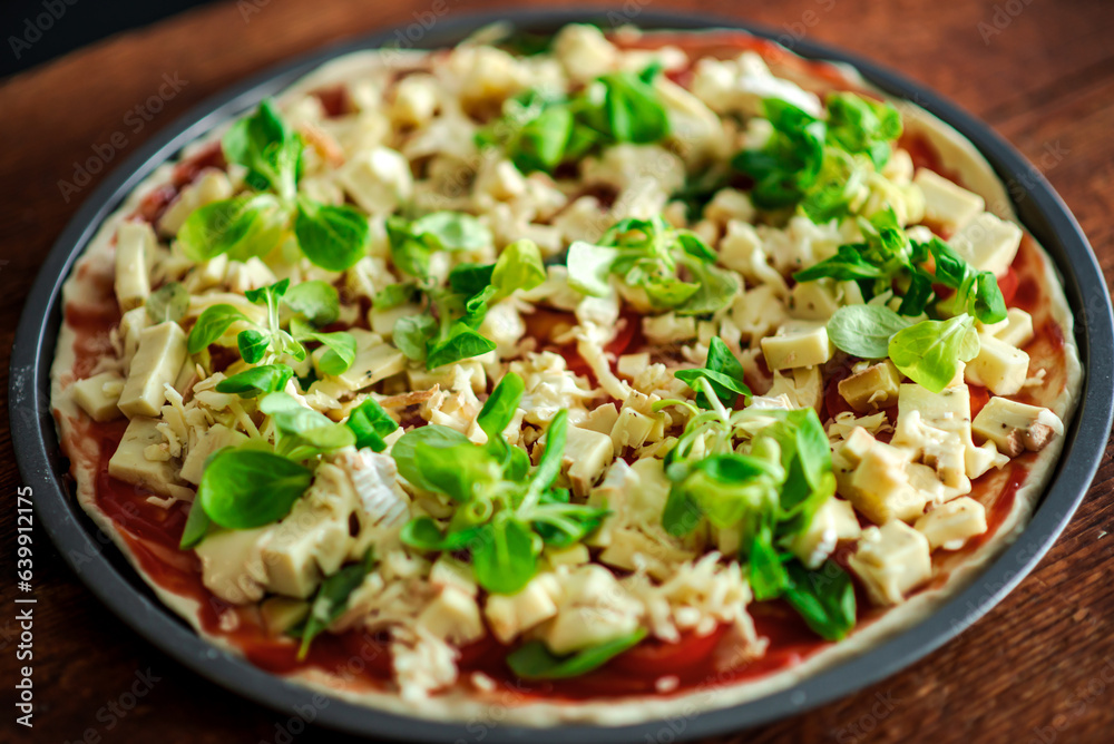 Pizza with lots of cheese and herbs. Cheesy pizza in a round shape on a wooden background. Pizza with lots of cheese and herbs. Cheesy pizza in a round shape on a wooden background.