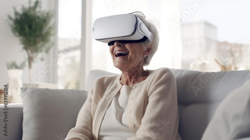 Happy old woman wearing VR technology headset on sofa in white living room