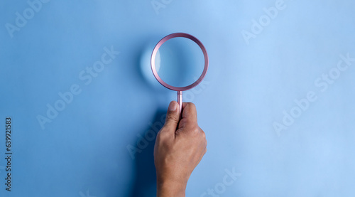 searching, securing, magnifier, icon, man, hand, blue, assurance, family, background. hold a magnifier to searching or find something at blue background. not has icon and symbolic isn't show.