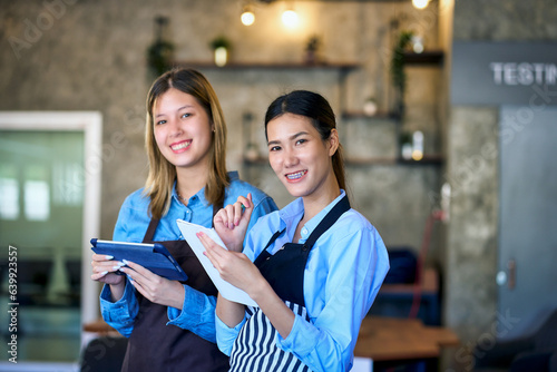 Two junior barista girls smile and lecture for learning in coffee cafe to be profressional of coffee maker. photo