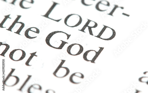 Word "God" on a page in a book, single word macro detail closeup, zoom shot, nobody God, deity, sacrum simple abstract concept, spirituality, religion and faith universal symbol, no people, Holy Bible