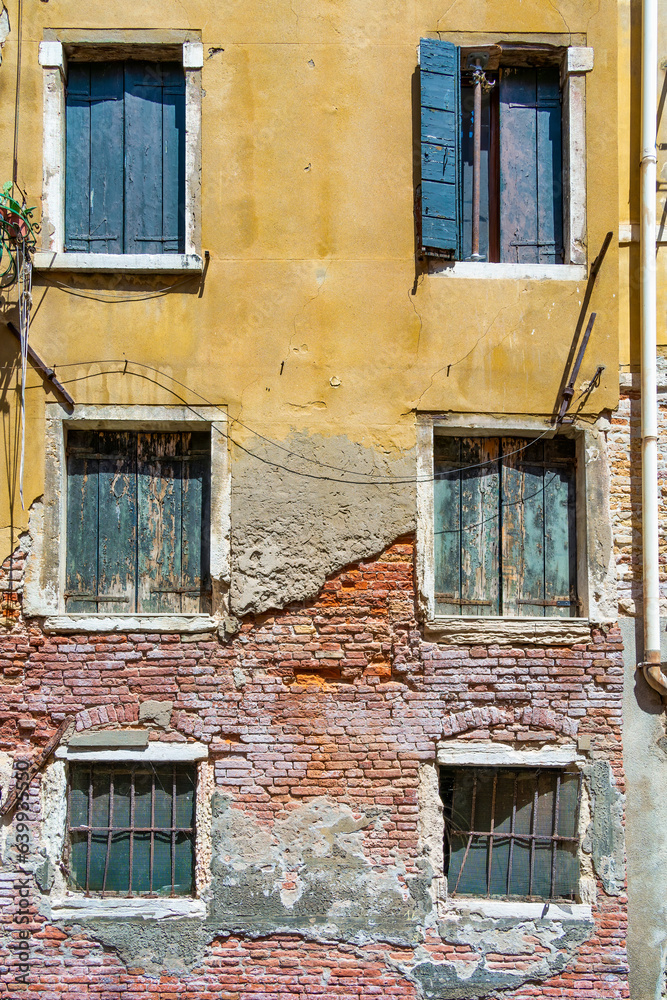 Old medieval worn out brick wall building in Venice, Italy.