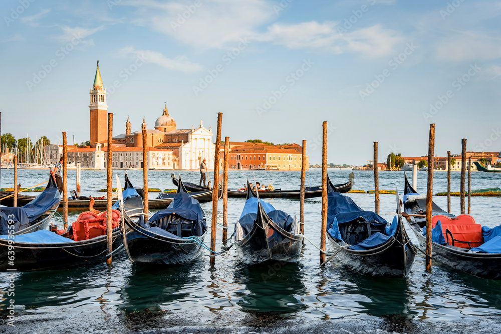 Picture with gondolas moored on Grand Canal near Saint Mark square, in Venice Italy with Church of San Giorgio Maggiore in the background.