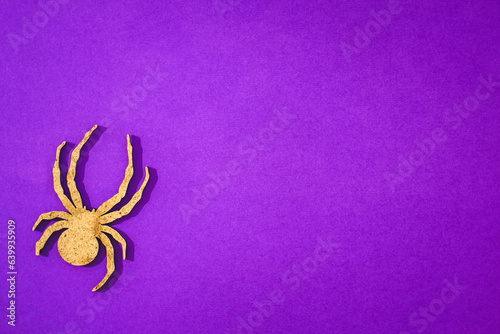 Wooden spider toy on purple background Halloween concept