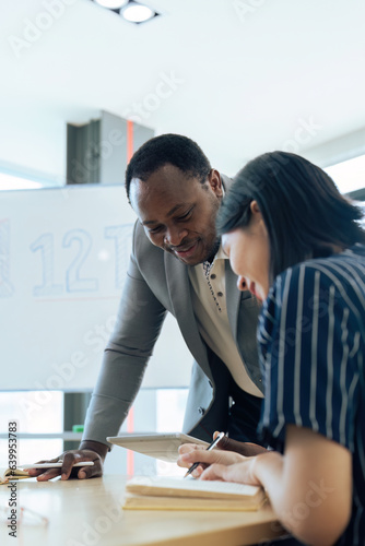 Mature professor talking to his student while assisting her on a class at the university photo