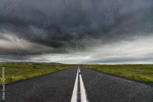 Route déserte avec des nuages très sombres en Islande