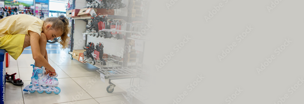 A teenage girl puts on new roller skates in a sports store. Fitting before purchase. Banner A teenage girl puts on new roller skates in a sports store. Fitting before purchase. Banner