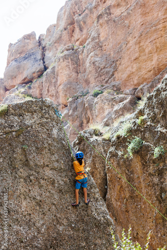 climber boy. a child in a helmet climbs a rock. sports on the street.