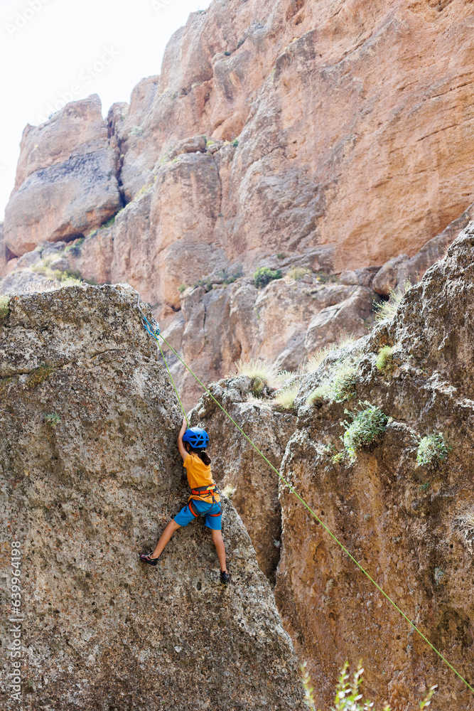 climber boy. a child in a helmet climbs a rock using equipment. children's sports. climber boy. a child in a helmet climbs a rock using equipment. children's sports.