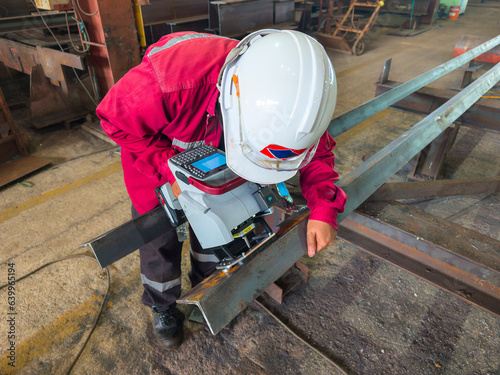 A worker is Stamping a Number on a Steel Structure Piece with a Mobile dot peen marker.