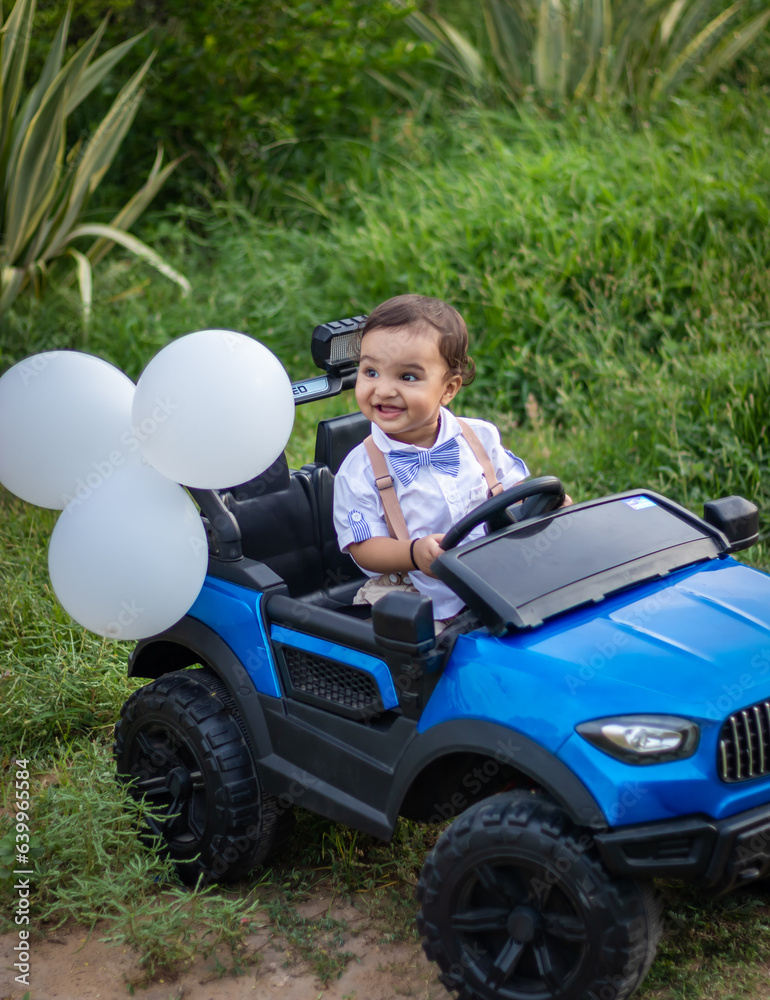 isolated cute toddler with innocent facial expression at toy car at outdoor from different angle isolated cute toddler with innocent facial expression at toy car at outdoor from different angle