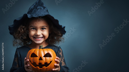 Smiling child in witch costume for Halloween on studio background photo