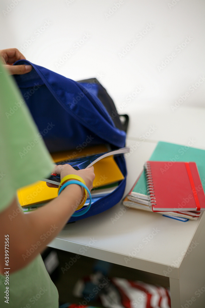 School year; packing a backpack; putting books and notebooks in a ...