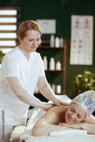 medical massage therapist in spa salon massaging client