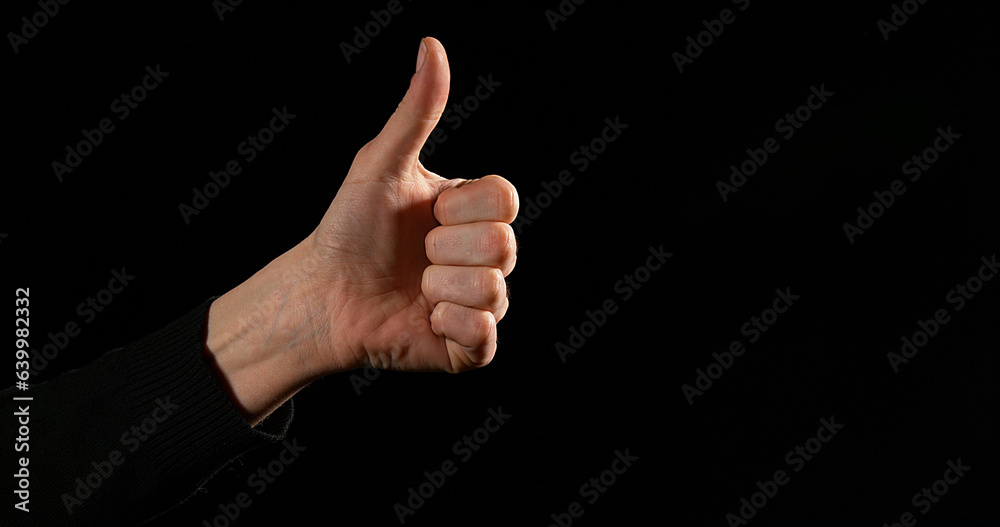 Hand of Woman making Sign against Black Background Hand of Woman making Sign against Black Background