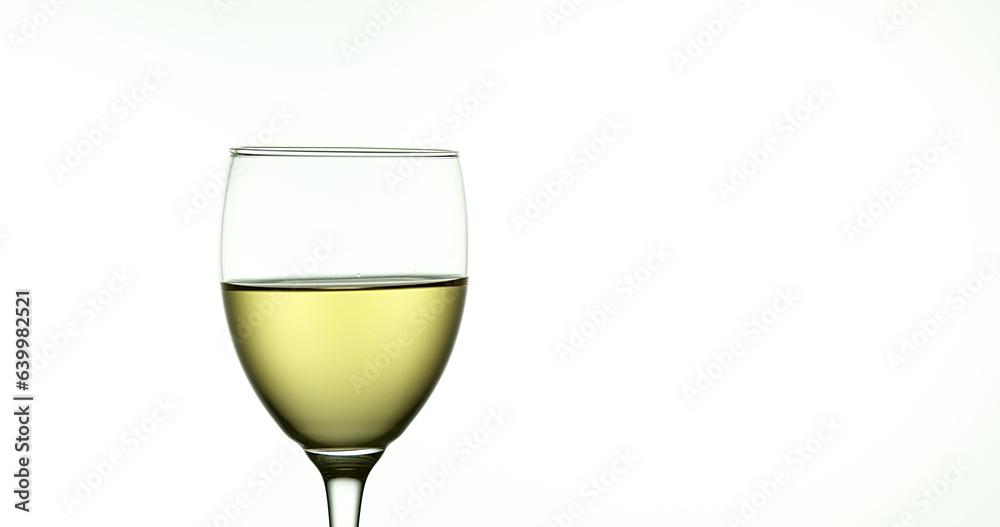 White Wine being poured into Glass, against White Background White Wine being poured into Glass, against White Background
