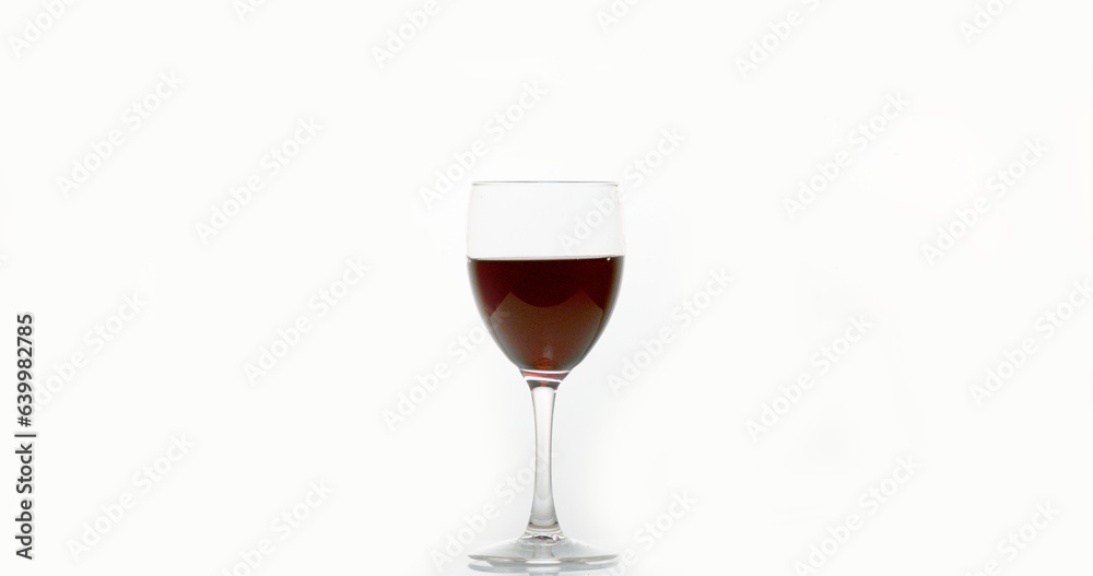 Red Wine being poured into Glass, against White Background Red Wine being poured into Glass, against White Background