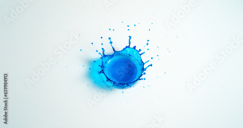 Blue Liquid falling into Water against White Background