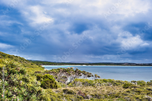 Unspoiled coastal scenery in Two Peoples Bay Nature Reserve, close to Albany, Western Australia. In the distance the long beach along the bay. Dark clouds. 