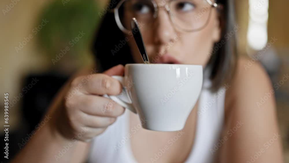 Young beautiful hispanic woman drinking coffee sitting on the table at cafeteria Young beautiful hispanic woman drinking coffee sitting on the table at cafeteria