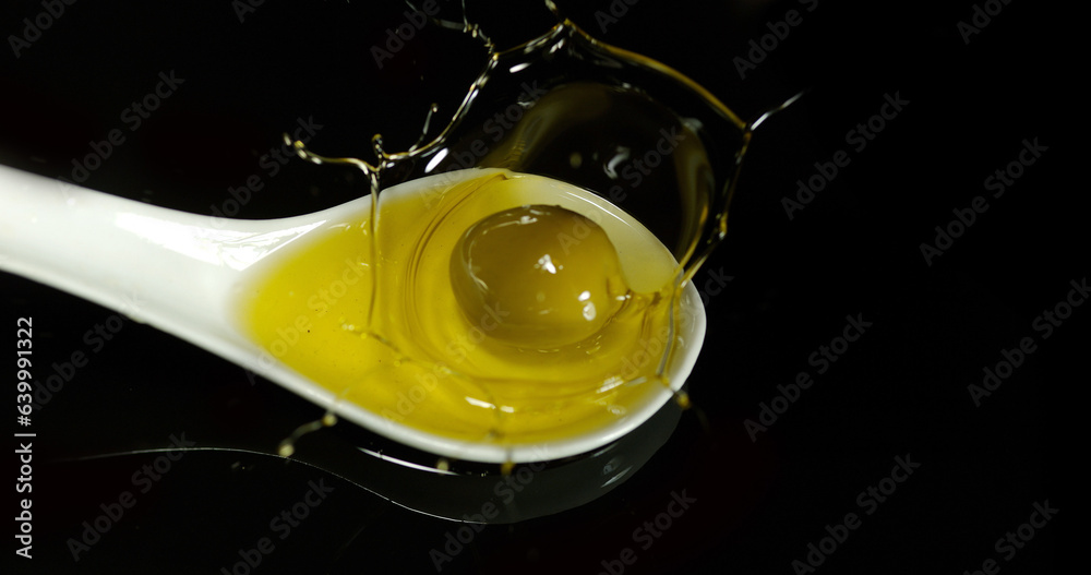 Green Olive, Olea europaea, Falling in a Spoon against Black Background Green Olive, Olea europaea, Falling in a Spoon against Black Background