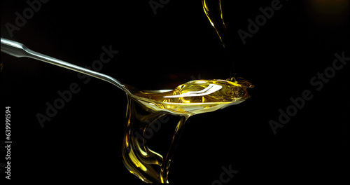 Olive Oil, Falling in a Spoon against Black Background
