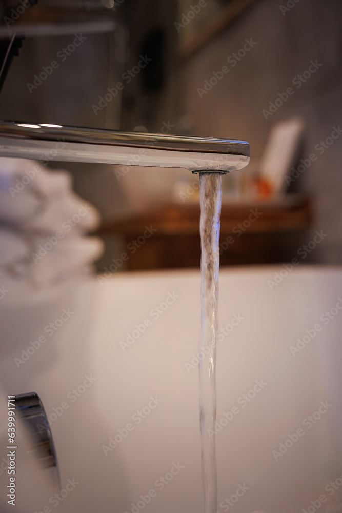 bathtub faucet open with water in elegant and beautiful bathroom for bathing, waste of water