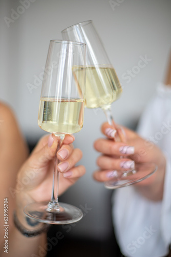 two hands holding glasses of champagne
