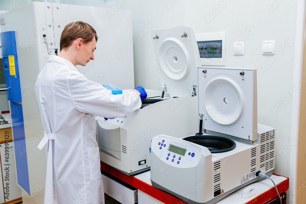 Scientist puts samples into centrifuge device Scientist puts samples into centrifuge device