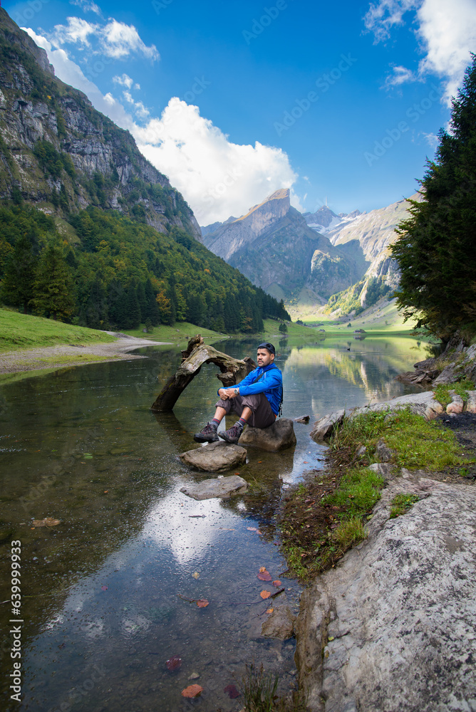 Φωτογραφία Bergidylle am Seealpsee in Appenzell in den Schweizer Bergen: Ein Wanderer genießt alpine Schönheit an einem Herbsttag