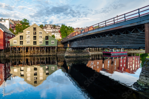 Fjord with wooden bridge and embankment with colorful wooden houses in Trondheim  Norway.