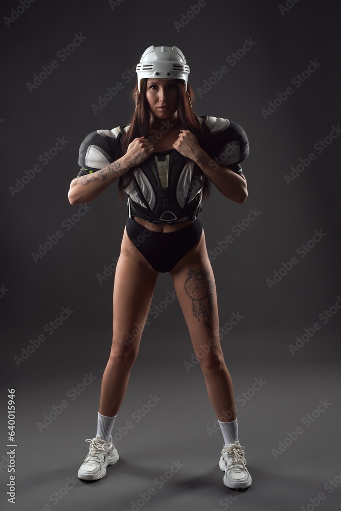 Female rugby player in lingerie on black background