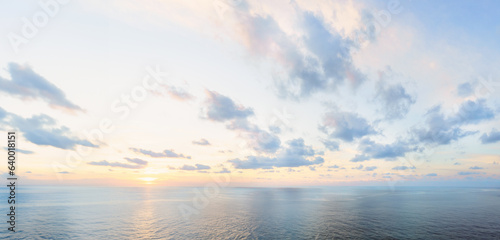Calm dawn sea panoramic background. Morning blue sky with colorful clouds - pastel neutral pink, purple, orange and yellow colors.