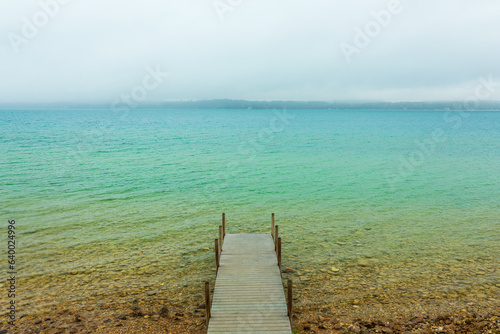Wooden dock on crystal clear blue Torch Lake in Northern Michigan.