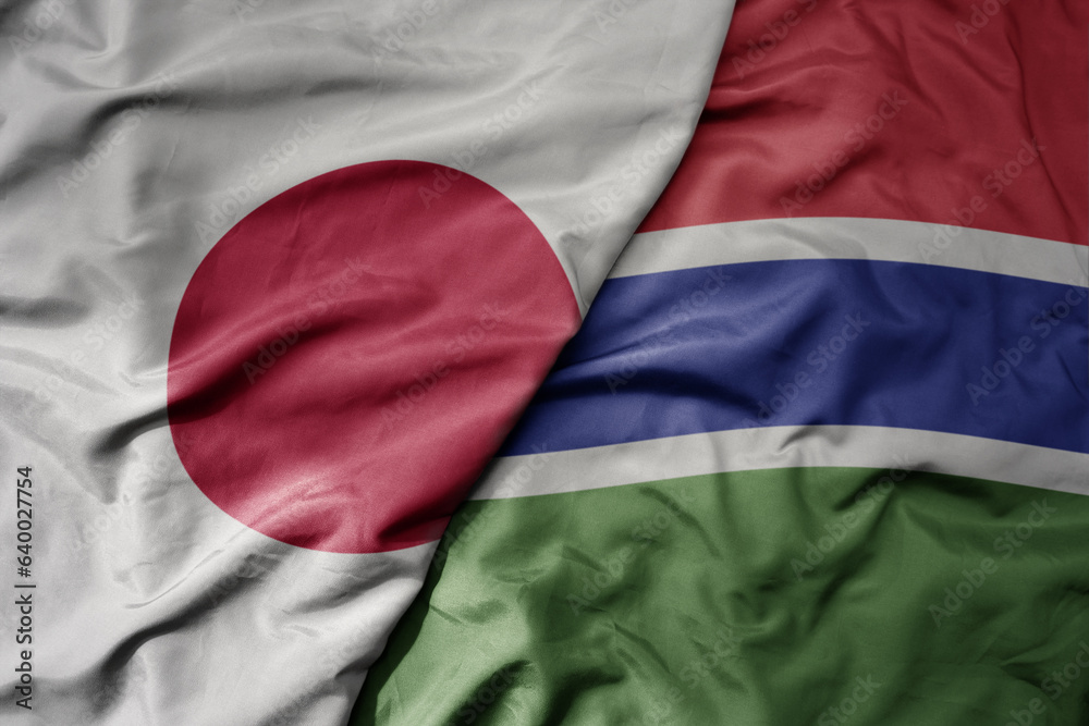 Fototapeta premium big waving national colorful flag of japan and national flag of gambia .