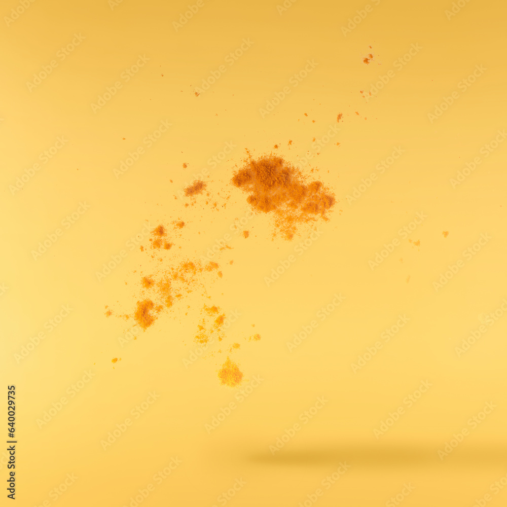 Fresh turmeric powder falling in the air isolated Fresh turmeric powder falling in the air isolated
