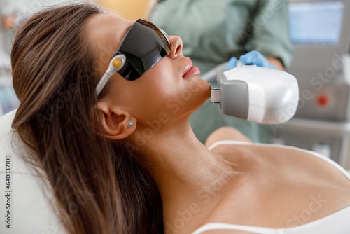 Close up of young woman face getting aesthetic face treatment in beauty salon. Cosmetology concept photo