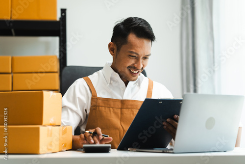 Startup SME small business entrepreneur of freelance Asian Indian man wearing apron prepare parcel delivery SME supply chain, procurement, package box to delivery. photo