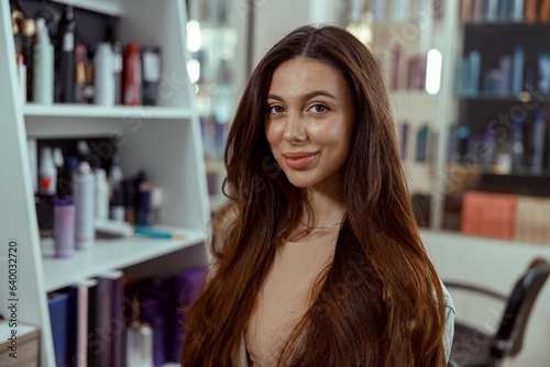 Beautiful brunette woman with long and shiny hair at beauty salon. Hair care concept