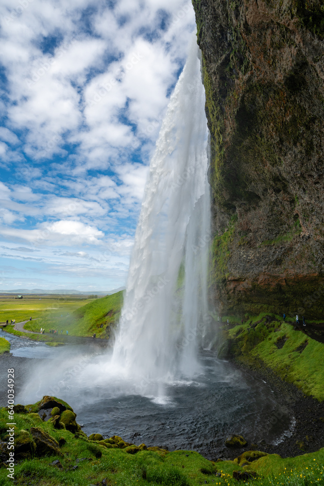 Seljalandsfoss Waterfall, view from walking behind the falls, In Iceland on a sunny day