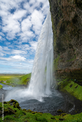 Seljalandsfoss Waterfall, view from walking behind the falls, In Iceland on a sunny day