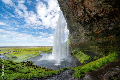 Seljalandsfoss Waterfall  view from walking behind the falls  In Iceland on a sunny day