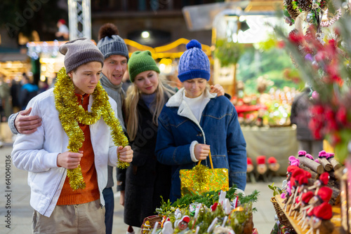 Winter holidays and celebration concept - happy mother, father and teenagers at christmas market © JackF
