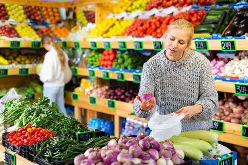 Portrait of teenage girl customer buying sweet oranges at grocery shop