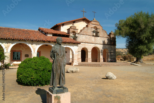 Mission San Antonio de Padua with statue of a Franciscan Friar. Old Adobe Mission in California